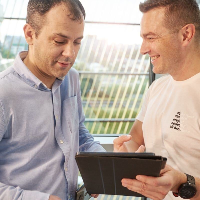 Createq romania colleagues looking at the tablet and smiling